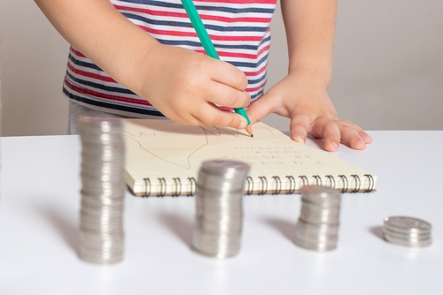 Building good money habits early — a child saving with coins
